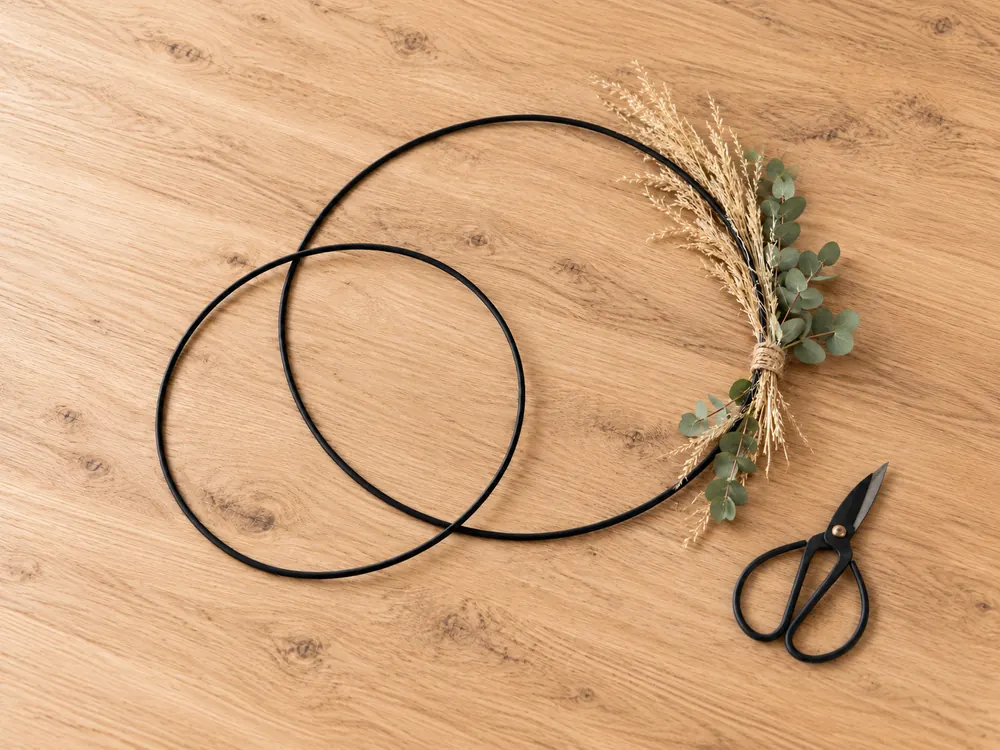 Schwarze Metallringe mit Trockengras und Eukalyptus