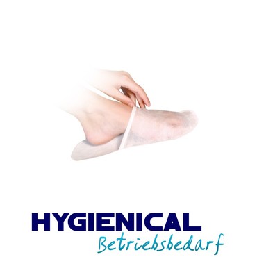 Hand zieht einen weißen Einwegslipper am Fuß zurecht, Seitenansicht Hand zieht einen weißen Einwegslipper am Fuß zurecht, Seitenansicht