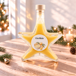Eierlikör 20 % Vol. in weihnachtlicher Sternflasche Eierlikör 20 % Vol. in einer Sternflasche auf hellem Naturholz mit warmem Lichtspiel, Tannenzweig, Glöckchen und Kerzenglas.
