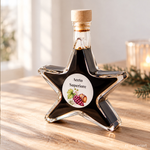 Aceto Superiore Balsamessig Sternflasche Feinkost-Geschenkflasche – Geschenkidee Sternflasche Feinkost-Geschenkflasche mit sämigem Balsamessig Aceto Balsamico Superiore (3% Säure) in weihnachtlicher Deko-Szene mit frischem Rosmarin und Weintrauben – perfekt als Feinkost-Geschenk, Mitbringsel oder Firmenpräsent für Genießer