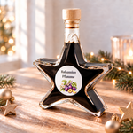 Balsamico Pflaume Sternflasche Feinkost-Geschenkflasche im festlichen Ambiente – Geschenkidee Sternflasche Feinkost-Geschenkflasche mit fruchtigem Pflaumen-Balsamessig (3% Säure) in weihnachtlicher Deko-Szene mit frischen Pflaumen und Zimtstangen – perfekt als Feinkost-Geschenk, Mitbringsel oder Firmenpräsent für Genießer