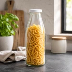 Transparente 1-Liter-Weithalsflasche aus Glas, gefüllt mit trockenen Nudeln zur Vorratsaufbewahrung
