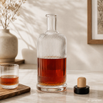 500-ml-Designglasflasche mit selbst gemachtem Likör 500-ml-Designglasflasche mit Likör und danebenliegendem Korken in neutraler Umgebung