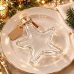 Leere Sternflasche mit Anhänger & Zimt als winterliche Tischdeko Leere Sternflasche, liegend auf einem Teller dekoriert mit Anhänger und Zimtstangen – winterliche Tischdeko-Idee für die Weihnachtszeit