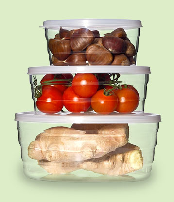 Drei gestapelte Frischhaltedosen aus Glas mit Maronen, Tomaten und Ingwer