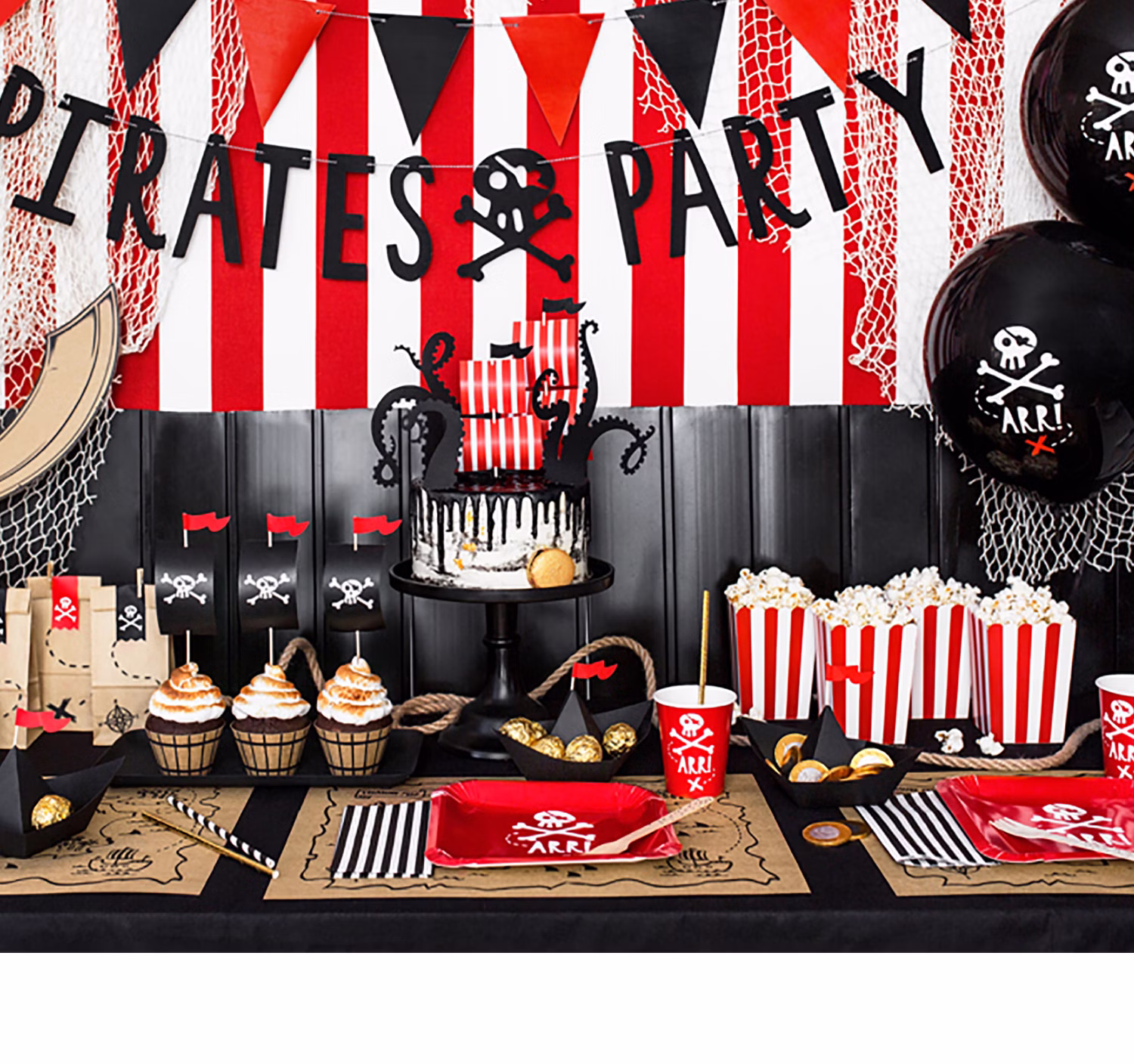 Komplett dekorierte Piratenparty mit Piratenbanner, roten Tellern, Popcornboxen, Ballons und schwarz-weißen Papierstrohhalmen.