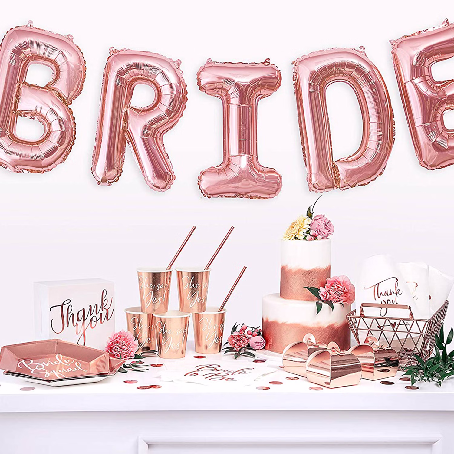 Roségoldene Bride Squad Partydekoration mit Papptellern, Bechern, Servietten und Ballonbuchstaben für die Brautparty.
