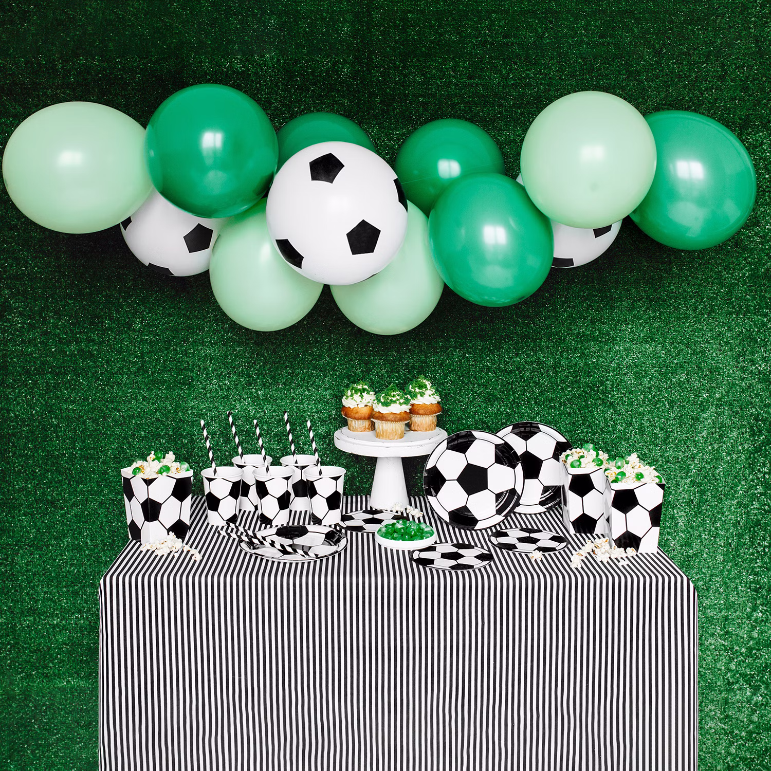 Komplett dekorierter Fußball-Partytisch mit Ballongirlande, Tellern, Bechern und Servietten.