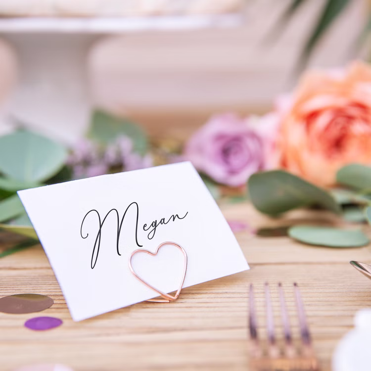 Tischkartenhalter Herzen Roségold 10 Stück Platzkartenhalter Hochzeit Geburtstag SALE Fotohalter Rosé Tischdeko Taufe Jugendweihe Kommunion Tisch-Deko Dekoration Zubehör Namenskarte mit Herz-Kartenhalter auf festlich gedecktem Tisch mit Blumenarrangement.