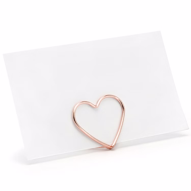Tischkartenhalter Herzen Roségold 10 Stück Platzkartenhalter Hochzeit Geburtstag SALE Fotohalter Rosé Tischdeko Taufe Jugendweihe Kommunion Tisch-Deko Dekoration Zubehör Leere Platzkarte wird von einem roségoldenen Herzhalter aus Metall sicher gehalten.