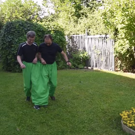 Wettrennen im Garten mit grüner Doppelhose von Vorne