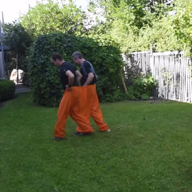 Wettrennen im Garten mit orangefarbener Doppelhose von der Seite