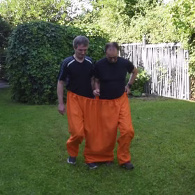Wettrennen im Garten mit orangefarbener Doppelhose von Vorne