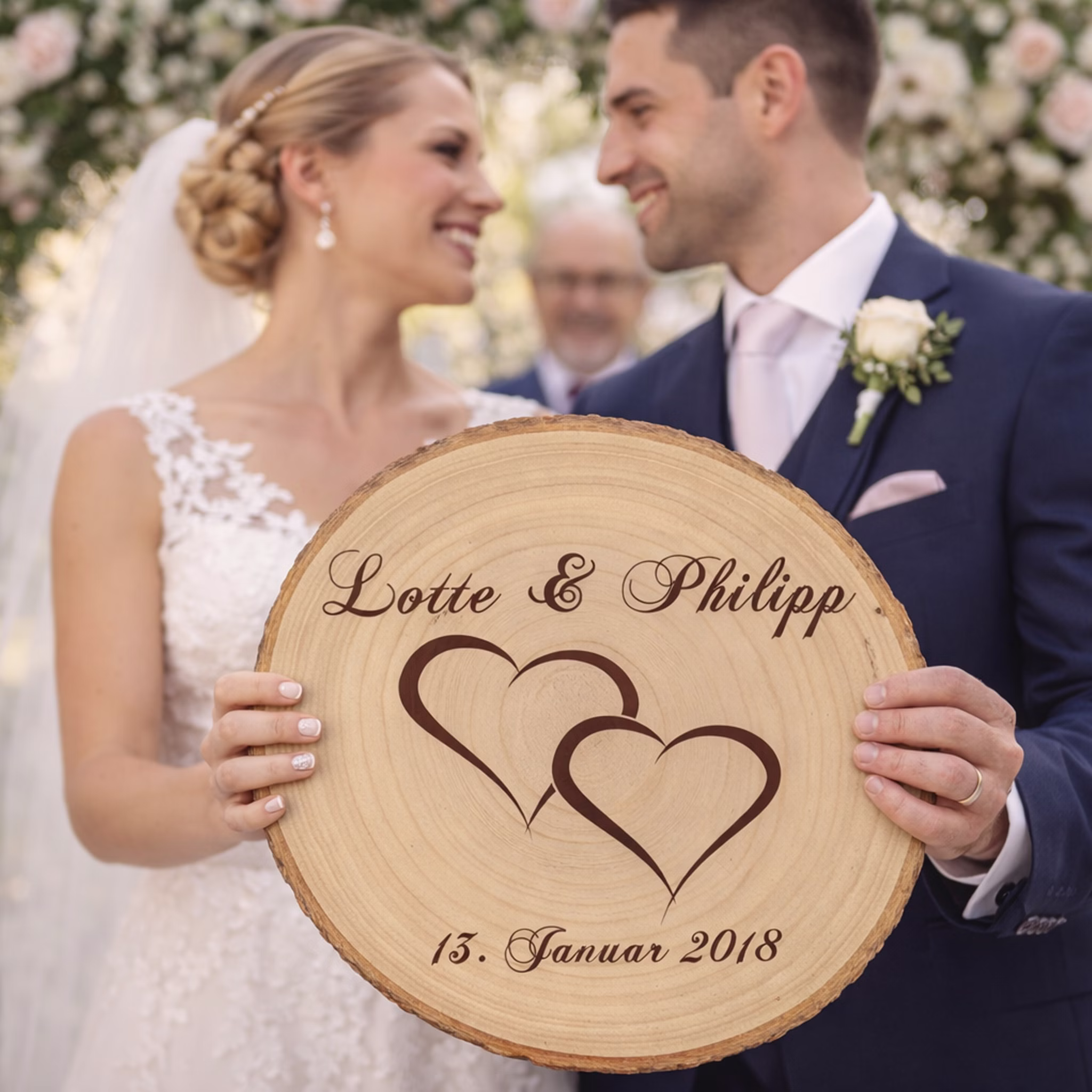 Baumscheibe mit Gravur Doppelherz Namen und Datum Hochzeit Jahrestag Holzscheibe Geschenkidee Brautpaar Hochzeitsgeschenk Braut und Bräutigam halten gemeinsam eine gravierte Holz-Baumscheibe mit Namen und Hochzeitsdatum während einer Trauungszeremonie im Freien Hinweis: KI generiertes Bild