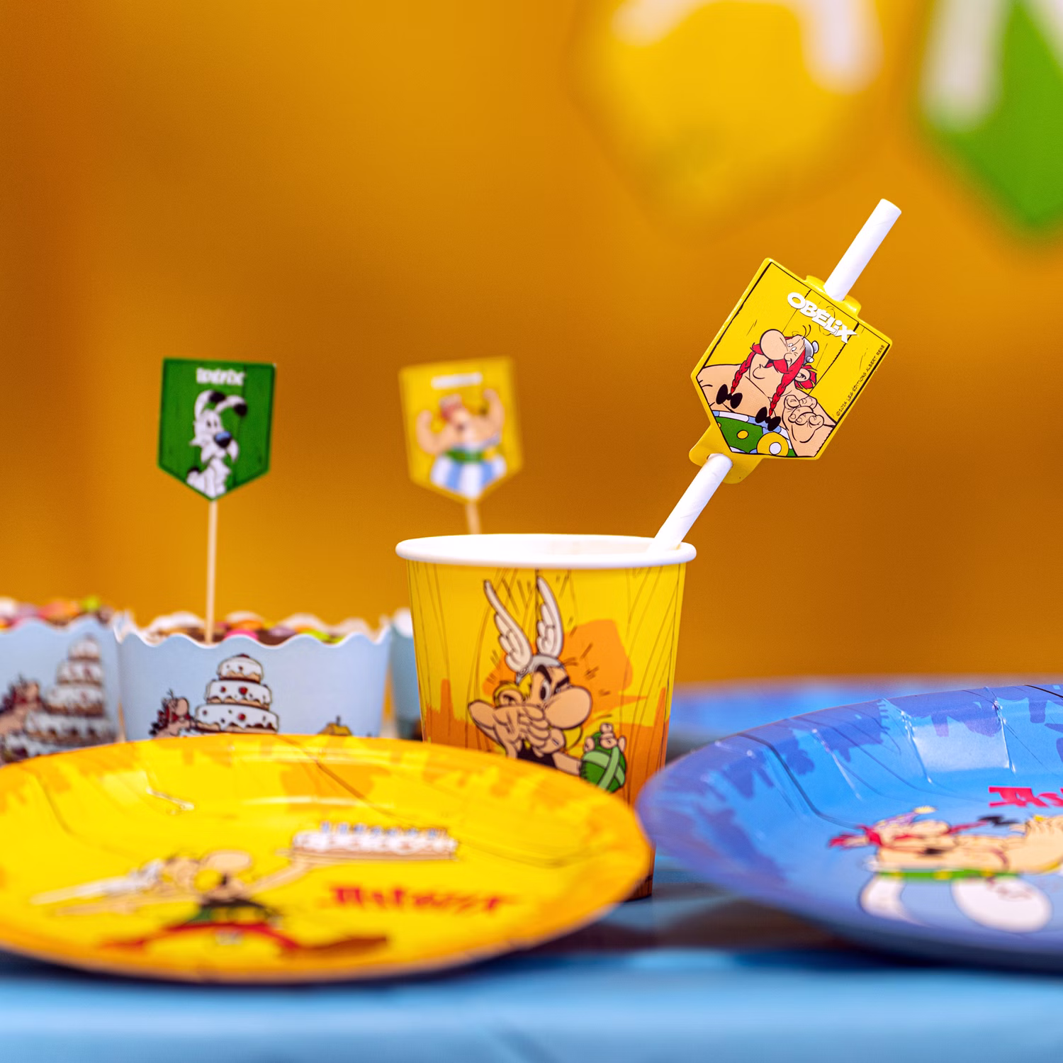 Asterix & Obelix Geburtstag Party-Set Tisch-Deko 52-tlg. Part-Deko Party-Zubehör Kindergeburtstag Comic-Helden Dekoration gedeckter Tisch Asterix & Obelix Partybecher mit Comicmotiv auf Geburtstagstisch neben Tellern und Dekoration.