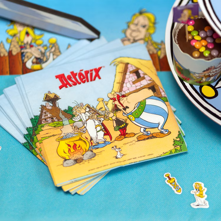 XXL Asterix & Obelix Geburtstag Party-Set Tisch-Deko 85-tlg. Part-Deko Kindergeburtstag Comic-Helden Dekoration gedeckter Tisch Stapel Asterix-Servietten mit gallischem Dorfmotiv auf türkisfarbener Tischdecke neben Partygeschirr und Dekoration.