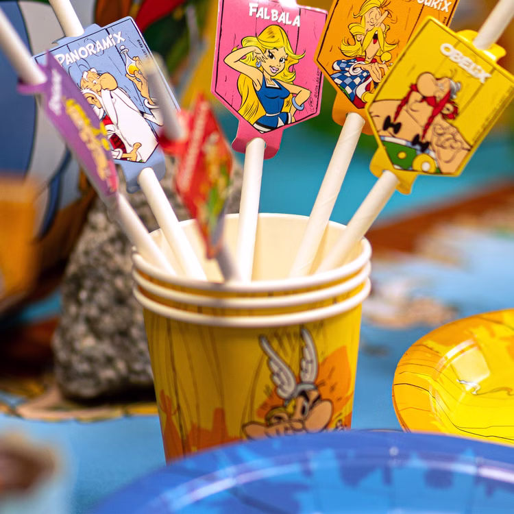 XXL Asterix & Obelix Geburtstag Party-Set Tisch-Deko 85-tlg. Part-Deko Kindergeburtstag Comic-Helden Dekoration gedeckter Tisch Papierstrohhalme mit Asterix & Obelix Figurenmotiven in Partybecher auf farbenfroher Geburtstagstafel.