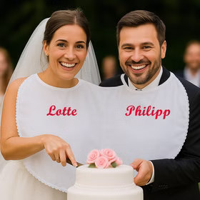 Braut & Bräutigam tragen das Doppel-Lätzchen mit Personalisierung und schneiden gemeinsam die Hochzeitstorte an Hinweis: KI generiertes Bild