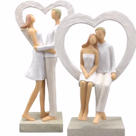 Brautpaar Figur Sitzend Liebe Weiß mit Herz Tischdeko Hochzeits-Deko Tisch-Deko Deko-Ideen Geschenkidee Braut & Bräutigam Zwei Brautpaar-Figuren im Herzrahmen, eine stehend umarmend, eine sitzend.
