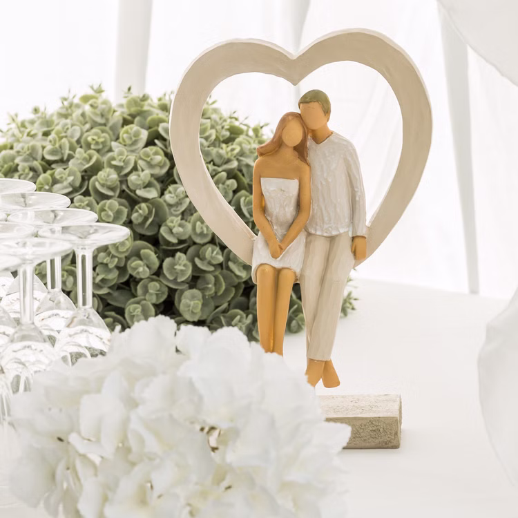 Brautpaar Figur Sitzend Liebe Weiß mit Herz Tischdeko Hochzeits-Deko Tisch-Deko Deko-Ideen Geschenkidee Braut & Bräutigam Hochzeitsfigur Brautpaar im Herzrahmen als Tischdeko mit Gläsern und Blumen.