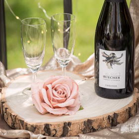 Baumscheibe Herzform Rustikales Holzherz 19 cm Tischdeko Hochzeit Geburtstag Vintage Dekoration Geburtstag Hochzeit Jubiläum Muttertag Deko-Ideen Dekorative Holz-Herzscheibe mit Rose und Sektgläsern dekoriert.