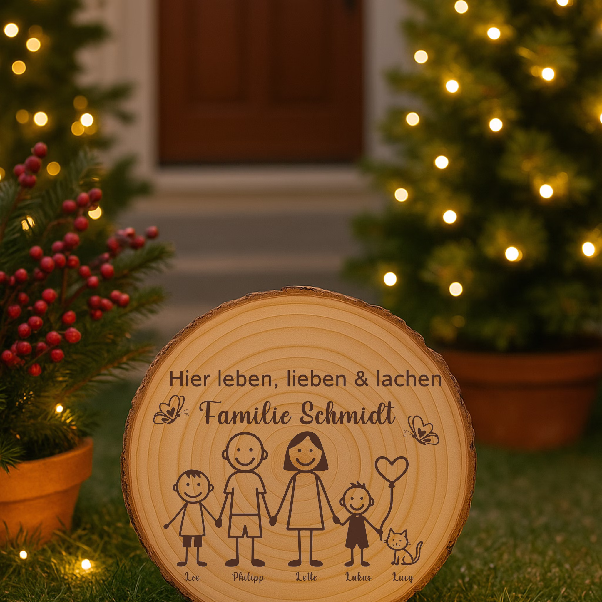 Baumscheibe 30 cm Familie Willkommensschild personalisiert mit zwei Jungen & Katze Zuhause Deko & Geschenk Eingangsbereich Geschenk für Familie und Freunde Einzug Herzlich Willkommen Holzscheibe personalisiert Gravierte Baumscheibe steht in einem stimmungsvoll beleuchteten Garten mit Pflanzen, roten Beeren und warmen Lichtakzenten im Hintergrund.