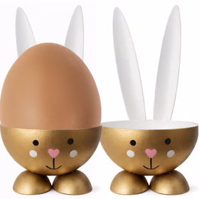Goldener Osterhasen-Eierbecher aus Metall mit eingesetztem braunen Frühstücksei; das Ei sitzt passgenau bis zum Rand in der Schale.