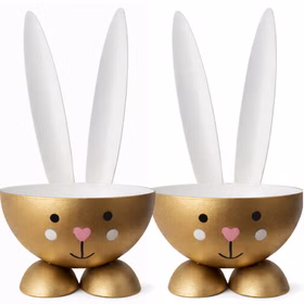 Zwei goldfarbene Eierbecher im Osterhasen-Design aus Metall nebeneinander stehend mit weißer Innenseite, Hasenohren und liebevoll gestaltetem Gesicht.