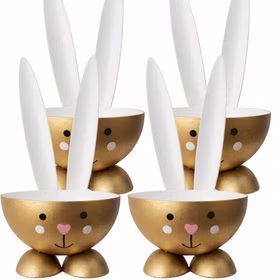 Vier goldene Eierbecher in Hasenform aus Metall nebeneinander auf weißem Hintergrund.