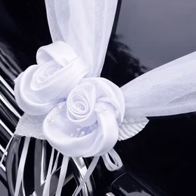 Autoschmuck Deko 2 Girlanden mit Blüten Weiß 180 cm Motorhaube Hochzeitsauto Wedding Car Organza-Girlande mit Rosenblüten Dekoration Nahaufnahme einer weißen Organza-Girlande mit zwei dekorativen Rosenblüten auf der Motorhaube eines schwarzen Autos befestigt.