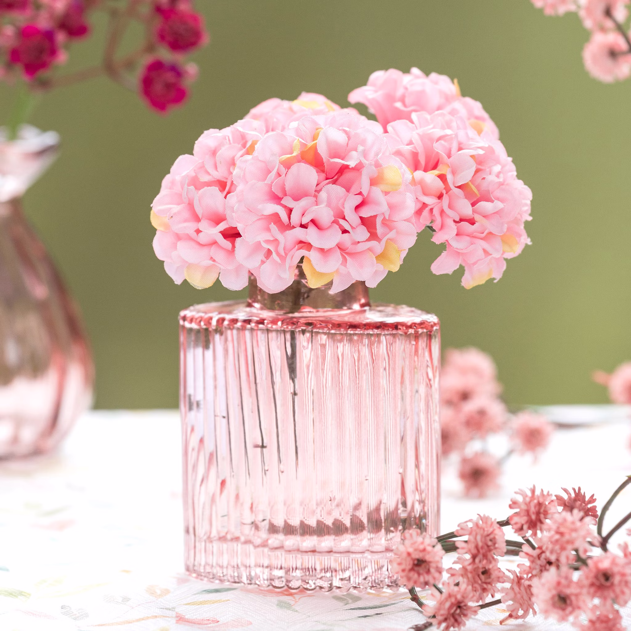 Mini Glasvasen-Set 6er Rosa Grün Klar Tisch-Deko Hochzeit Geburtstag gedeckter Tisch Blumenvase kleine Glasvase Dekoration Events Rosa Mini-Glasvase mit feiner Rillenstruktur und zarten rosa Blüten als dekorativer Blickfang auf dem Tisch.