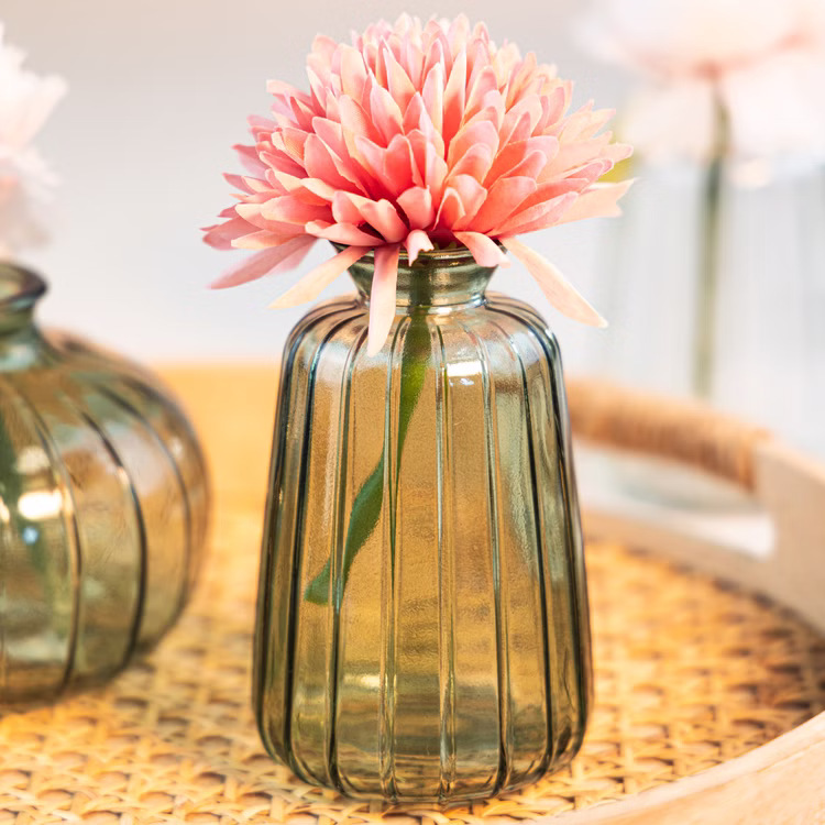 Glasvasen Verone 6er Tischvase Rosa Grün & Transparent Tisch-Deko Hochzeit Geburtstag Vase aus Glas festliche Tischdeko Wohnaccessoire Glasvase dekorativ Grüne Glasvase Verone mit rosa Blüte auf dekorativer Tischfläche, kombiniert mit warmem Licht und natürlichem Hintergrund.