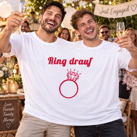 Doppel T Shirt Ring drauf Verlobungsfeier Zwei Männer tragen gemeinsam das Doppel-T-Shirt „Ring drauf“ und stoßen bei einer Verlobungsfeier mit Gästen und Sekt an. Hinweis: KI generiertes Bild