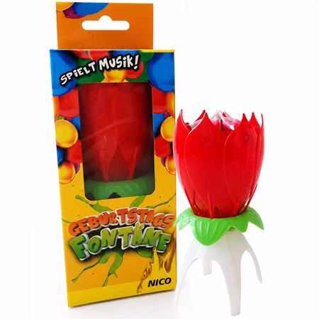 Nico Geburtstagsfontäne Verpackung Produktansicht NICO Geburtstagsfontäne mit Musik neben der bunten Originalverpackung, rote Kerzenblume mit grünem Sockel und weißem Standfuß.