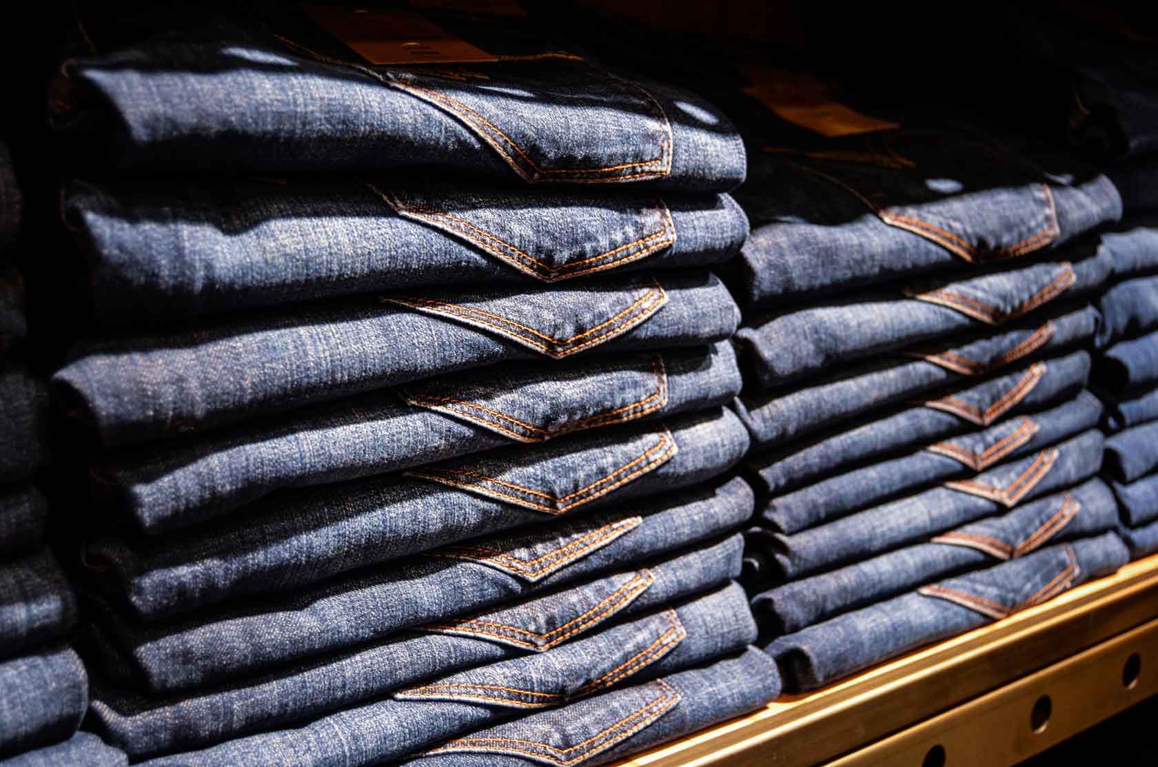 Gestapelte Jeans im Regal