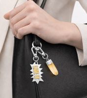 Elegante set de charms Calvin Klein Downtown: Colgantes de acero inoxidable con resina en contraste y la inscripción "LIVE IT" - Accesorios para bolsos - 7 x 1,3 cm - KJJCJA090100 - Plateado/Amarillo