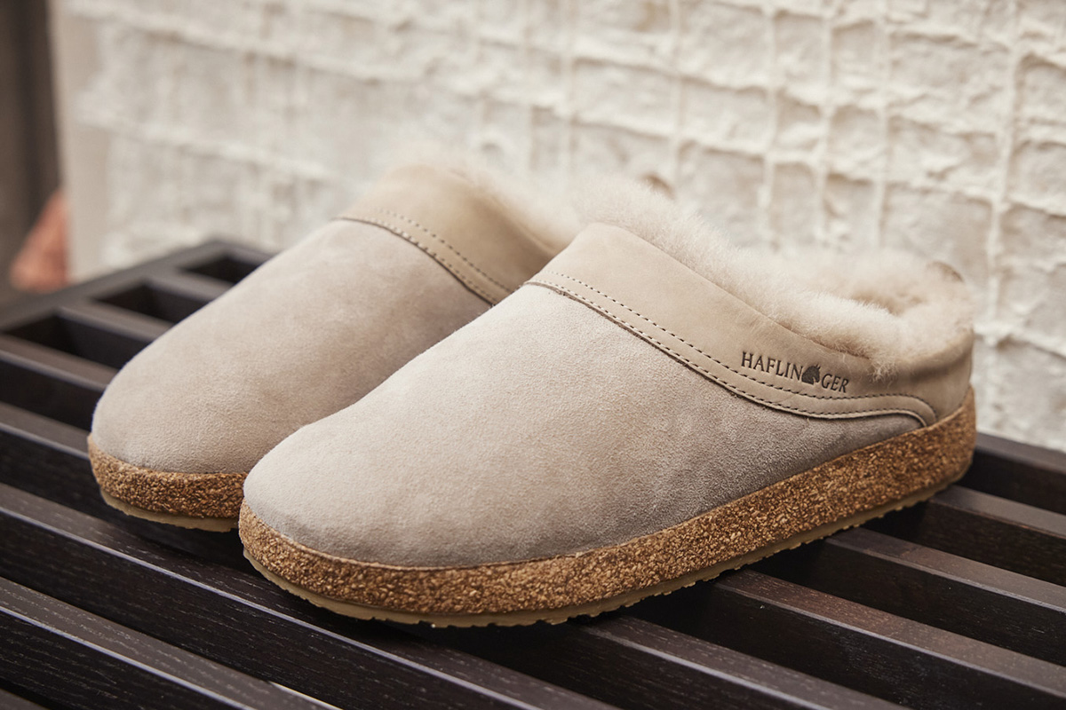 Haflinger Damen Lammfellclogs aus weichem Veloursleder mit kuscheligem Lammfellfutter und anatomischem Korkfußbett für warme und bequeme Füße zuhause.