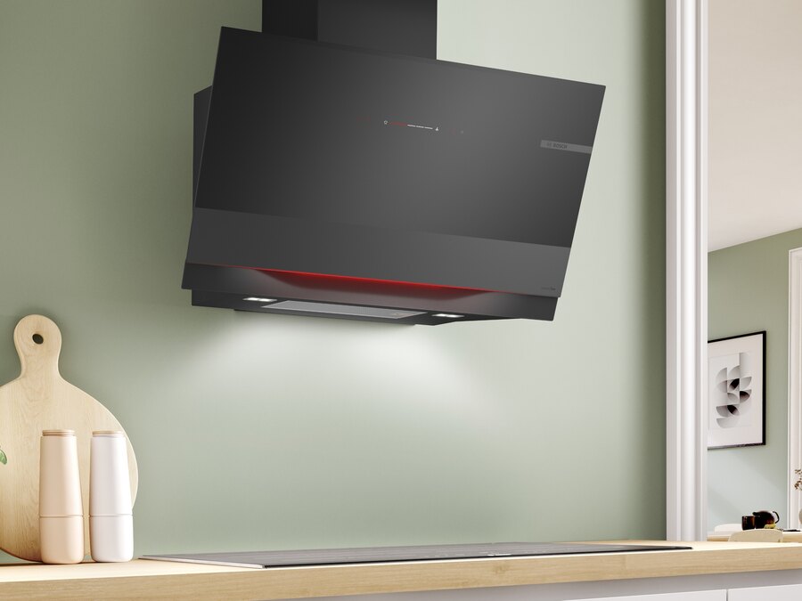 Schwarze schräge Bosch Kopffreihaube vor einer salbeigrünen Wand, darunter ein rotes Lichtband.