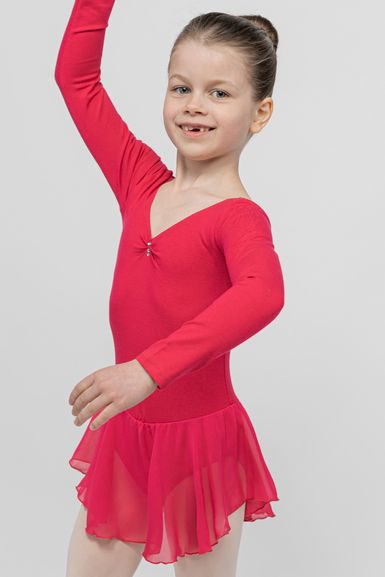 Ein junges Mädchen in einem roten Ballett-Outfit hebt lächelnd einen Arm und posiert.