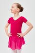 Ein junges Mädchen in einem rosa Ballettkleid steht mit den Händen in den Hüften und blickt zur Seite. 1