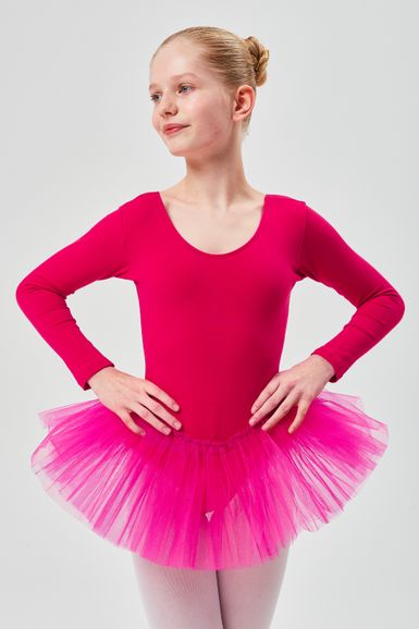 Ein junges Mädchen in einem leuchtend rosa Ballettbody und Tutu steht mit den Händen in den Hüften.