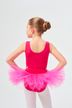 Ein junges Mädchen in einem rosa Ballettbody und Tutu steht mit den Händen in den Hüften und blickt von der Kamera weg. 3