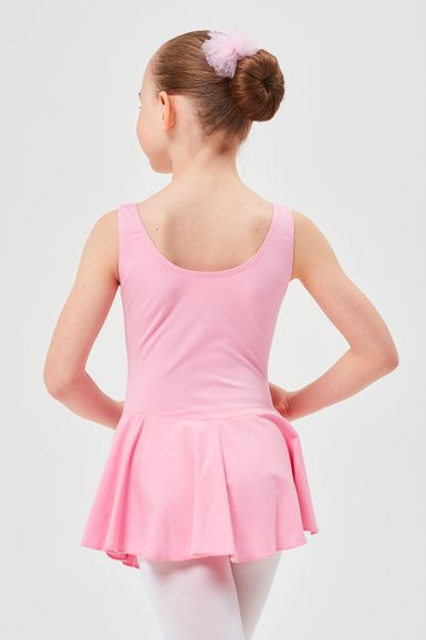 Ein junges Mädchen in einem rosa Ballettbody und Tutu steht mit abgewandtem Gesicht da