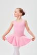 Ein junges Mädchen in einem rosa Ballett-Outfit streckt ihren Rock aus und lächelt 1
