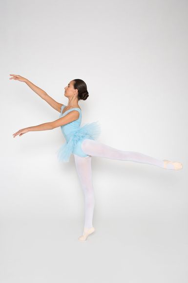 Eine Ballerina in einem blauen Tutu führt eine Arabeskenpose aus.