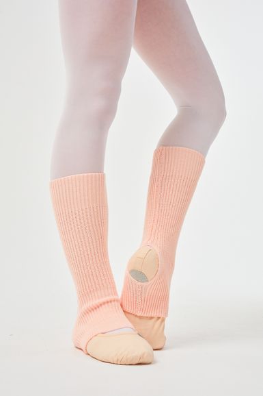 Person mit hellrosa Beinwärmern und Ballettschuhen