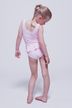 Ein junges Mädchen in einem blassrosa Ballettbody steht barfuß da und blickt mit dem Rücken und der Seite nach unten in die Kamera. 4