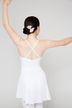 Eine Person in einem weißen Ballett-Outfit steht mit erhobenen Armen da 2