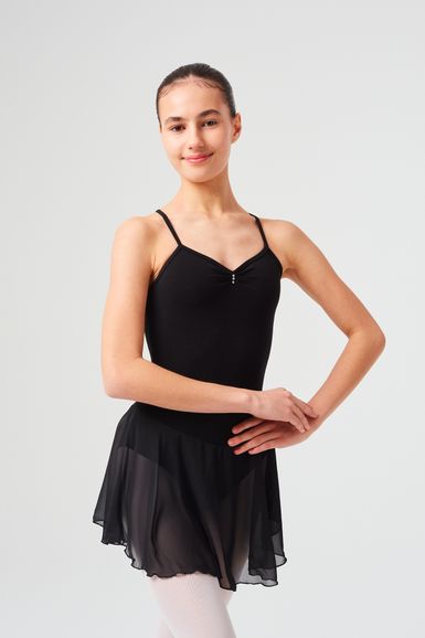 Junge Frau in schwarzem Ballettbody und Rock posiert vor schlichtem Hintergrund