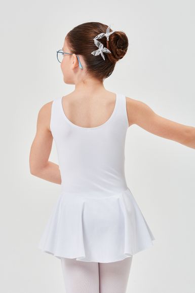 Ein junges Mädchen in einem weißen Ballettbody und Tutu steht mit dem Rücken zur Kamera und hat ihr Haar zu einem Dutt hochgesteckt